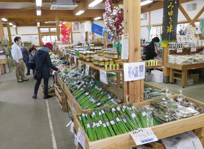 菜の花畑を望む道の駅の中にある直売所：飯山市